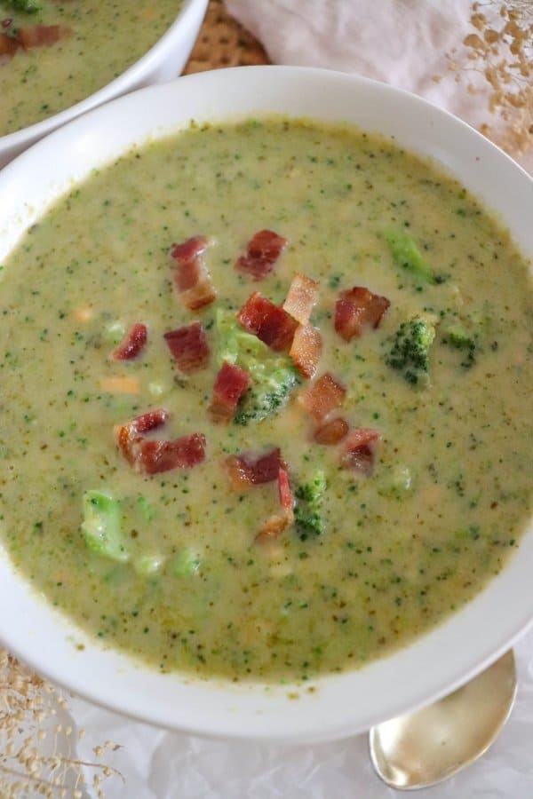 A bowl of broccoli cheddar soup recipe with crumbled bacon on top.