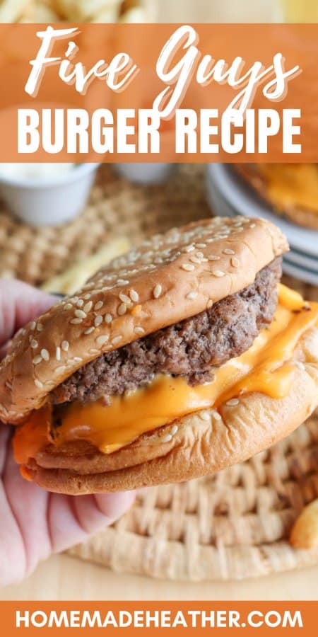 Copycat Five Guys Burger with melted American cheese and a sesame bun being held in a hand.