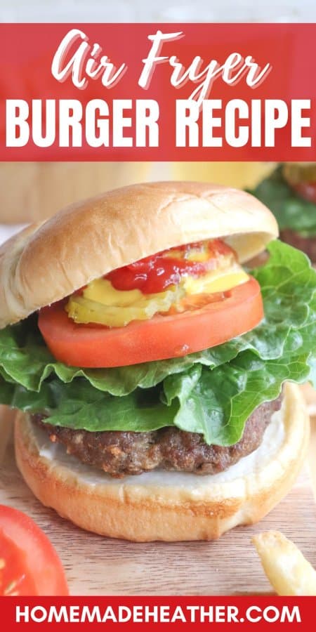 A burger cooked in the air fryer on a bun with lettuce, tomato, pickles, and condiments.