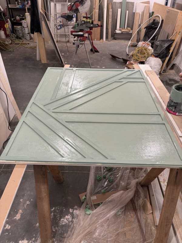 Painting the geometric trim art piece green.