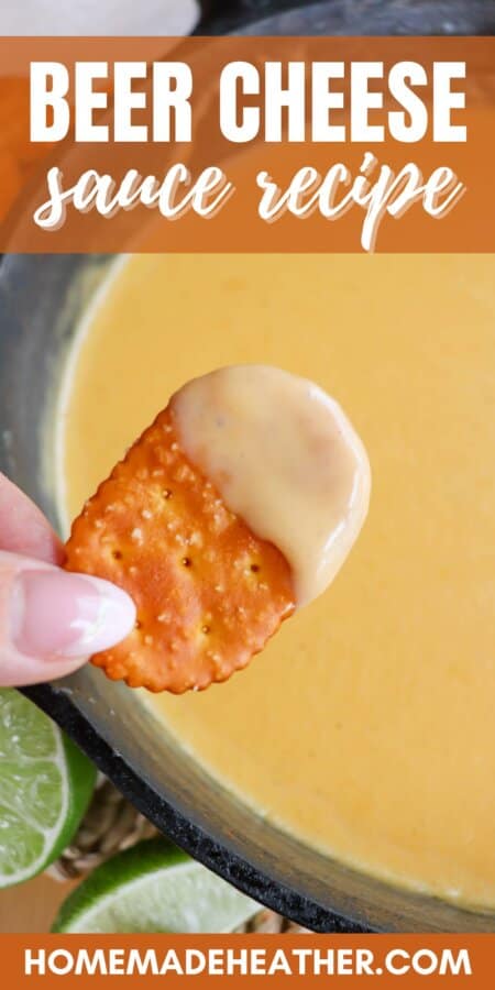 Fingers holding a pretzel cracker with cheese dip on it over a cast iron skillet of beer cheese sauce with text overlay.