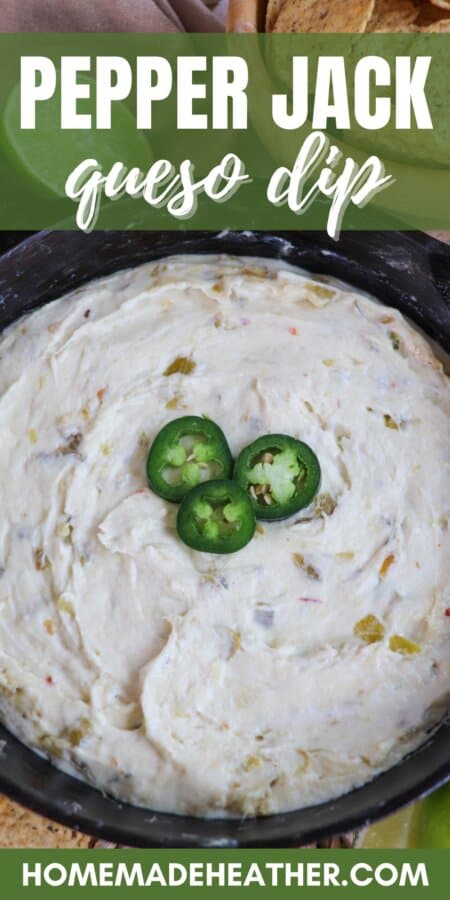 White pepper jack cheese dip in a cast iron skillet topped with three slices of jalapeno pepper and surrounded by tortilla chips and fresh lime on the table with a text overlay.