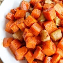 Cubes of cooked apple and sweet potato in a large white bowl.