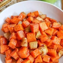 Cubes of cooked apple and sweet potato in a large white bowl.