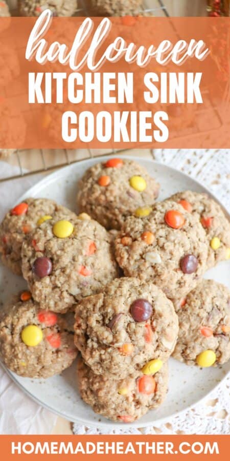 Oatmeal cookies with chocolate chips, orange and yellow M&Ms stacked on a cream plate.