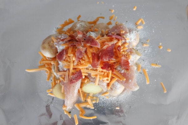 Ingredients for chicken bacon ranch packets on a sheet of aluminum foil.