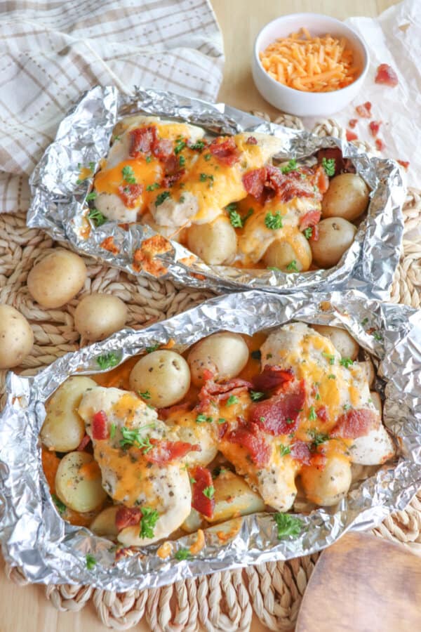 Chicken and baby potatoes covered in ranch seasoning, bacon bits and melted cheese in a foil packet.