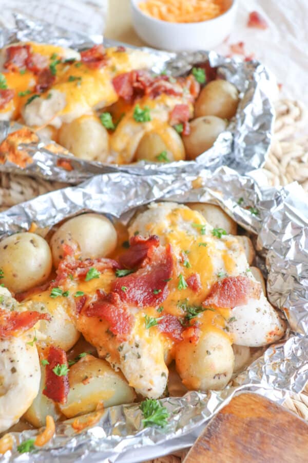 Chicken and baby potatoes covered in ranch seasoning, bacon bits and melted cheese in a foil packet.
