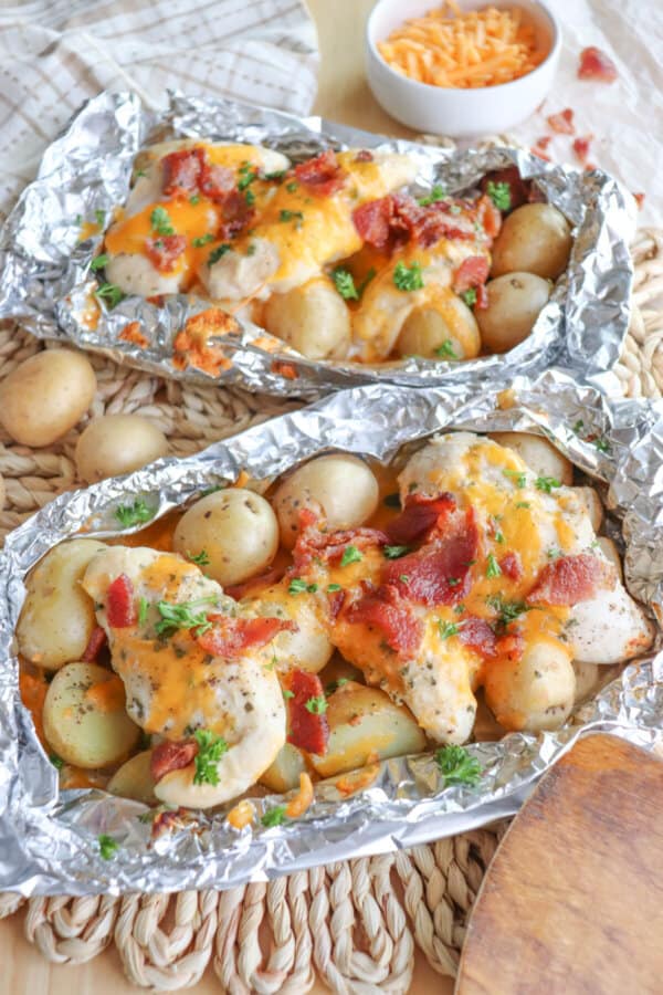 Chicken and baby potatoes covered in ranch seasoning, bacon bits and melted cheese in a foil packet.
