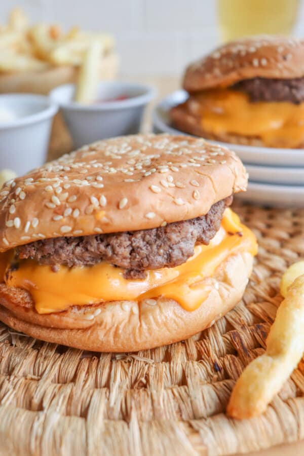 Close up of a five guys burger with melted American cheese on a sesame seed bun.