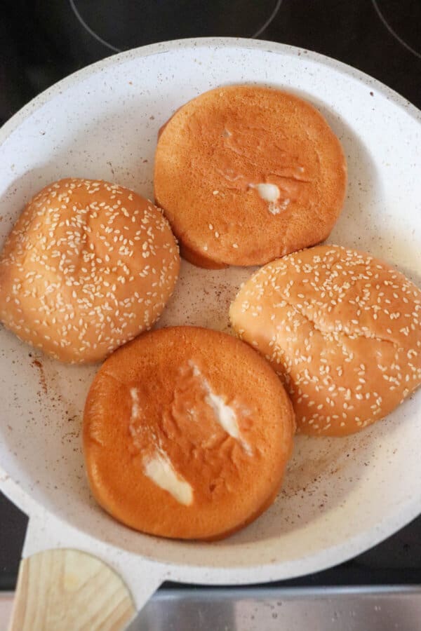 Five guys burgers toasted buns on a cream colored skillet.