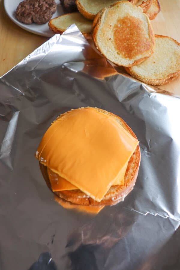 Five Guys Burger getting assembles with two slices of processed cheese.