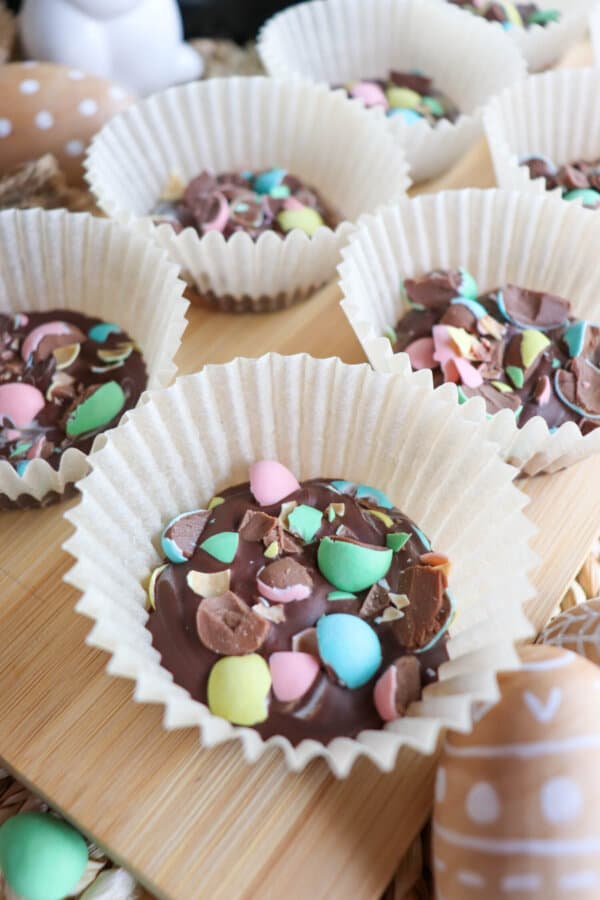 Mini Egg Crockpot Candy in a muffin cup on a wooden background.
