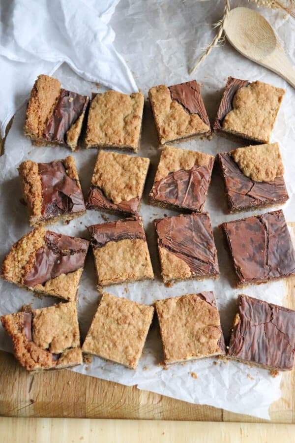 Starbucks Oat Bars with a chocolate fudge texture combined with oat cookie blobs cut into squares on parchment paper.