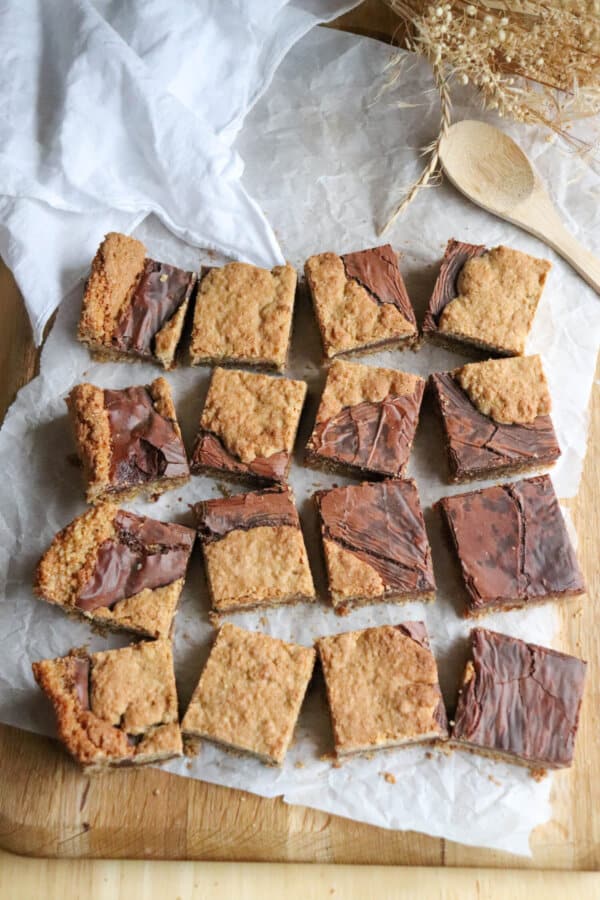 Starbucks Oat Bars cut into squares on parchment on a wooden background.