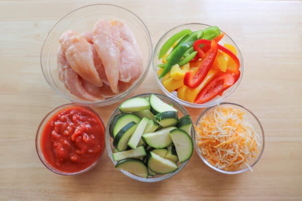 Ingredients for salsa chicken in glass bowls.