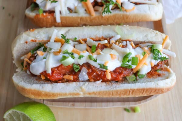 Taco hot dog with salsa and sour cream toppings.