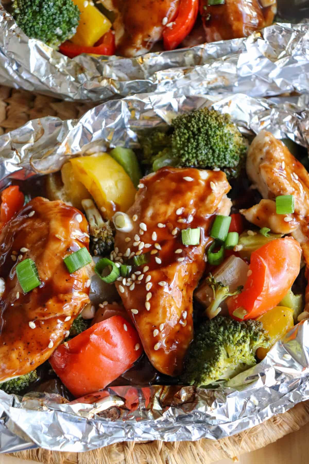 Chicken and vegetables covered in teriyaki sauce in a foil packet.