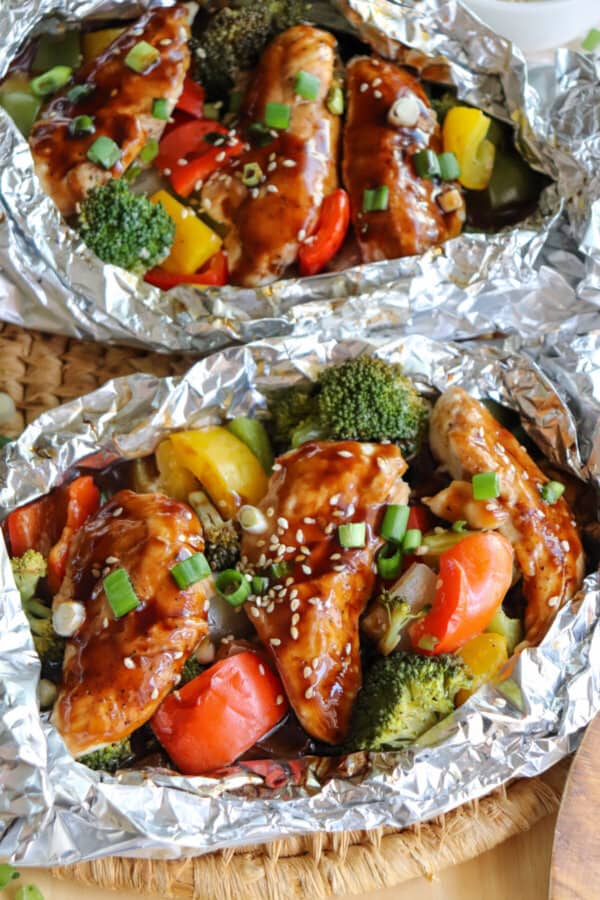 Chicken and vegetables covered in teriyaki sauce in a foil packet.