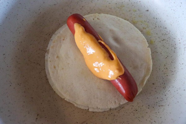 Tortilla with hot dog in a skillet