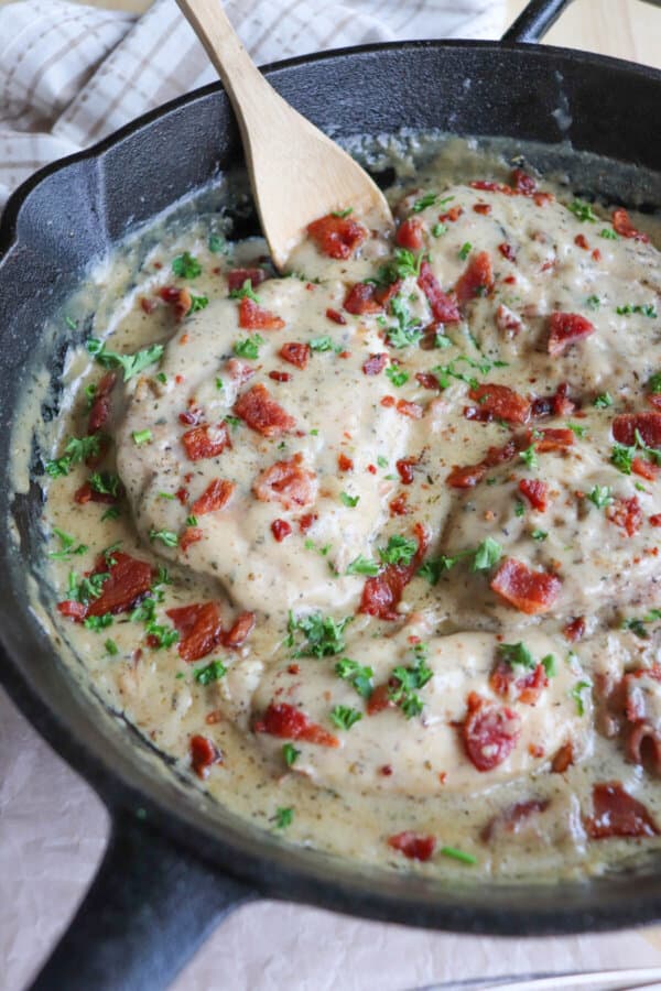 Chicken breast covered in a ranch cream sauce garnished with crisp bacon bits and parsley.