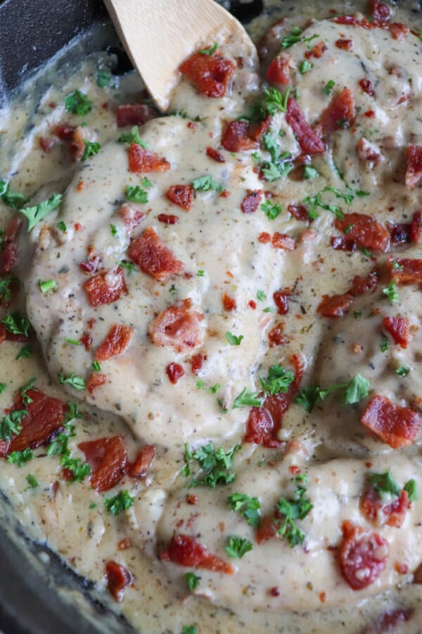 Chicken breast covered in a ranch cream sauce garnished with crisp bacon bits and parsley.