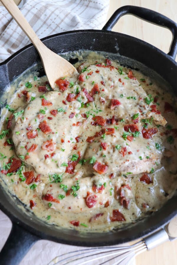Chicken breast covered in a ranch cream sauce garnished with crisp bacon bits and parsley.