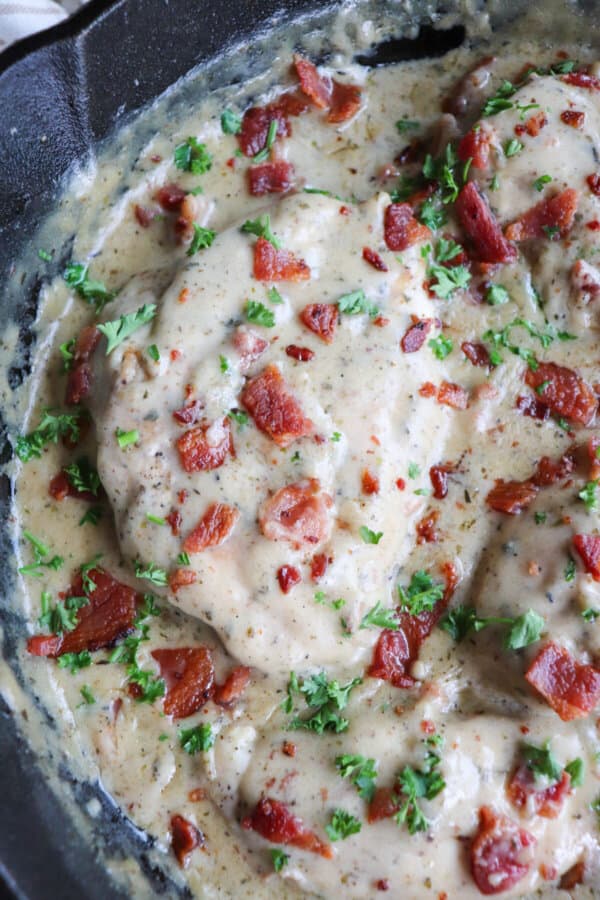 Chicken breast covered in a ranch cream sauce garnished with crisp bacon bits and parsley.