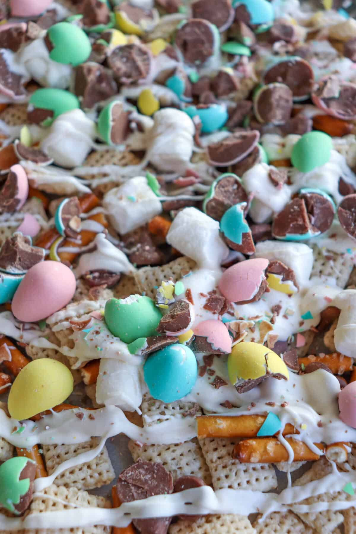 Easter snack mix with chex cereal, pretzels and chopped mini eggs drizzled with white chocolate.