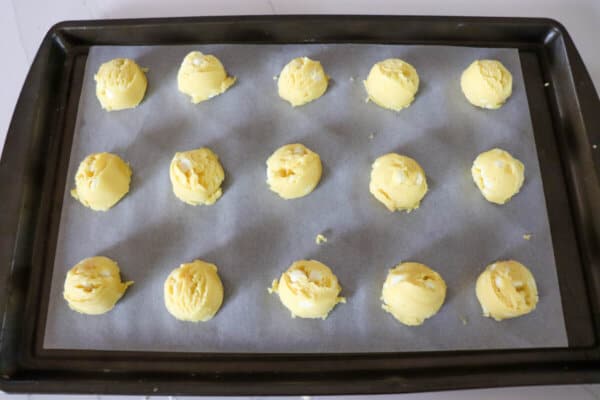 Lemon cookie dough balls on a baking sheet.