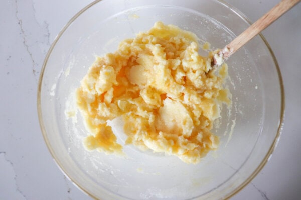 Butter, sugar, egg and vanilla creamed together in a clear glass bowl.