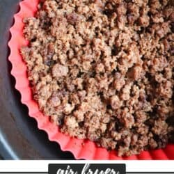 Ground beef seasoned with taco spices and cooked in the basket of an air fryer with a red liner.