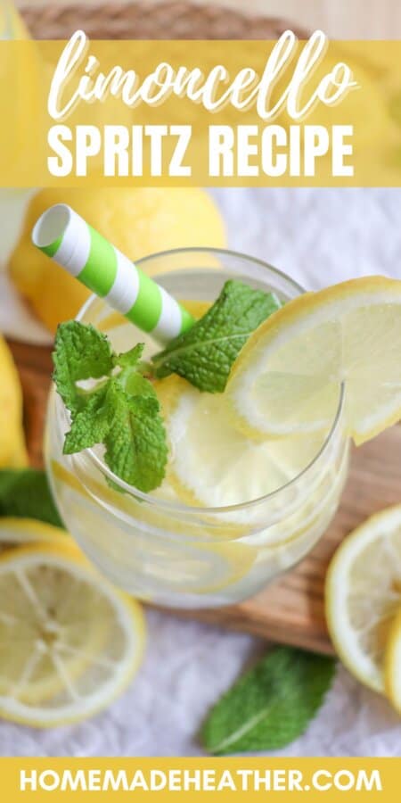 Glass of limoncello spritz with lemon slice garnish and mint leaves with a green and white straw.