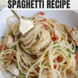 Cooked spaghetti in a cast iron skillet with chicken, bacon bits and garnished with fresh parsley.