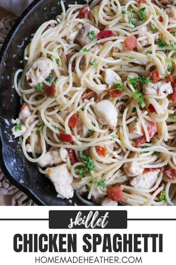 Cooked spaghetti in a cast iron skillet with chicken, bacon bits and garnished with fresh parsley.