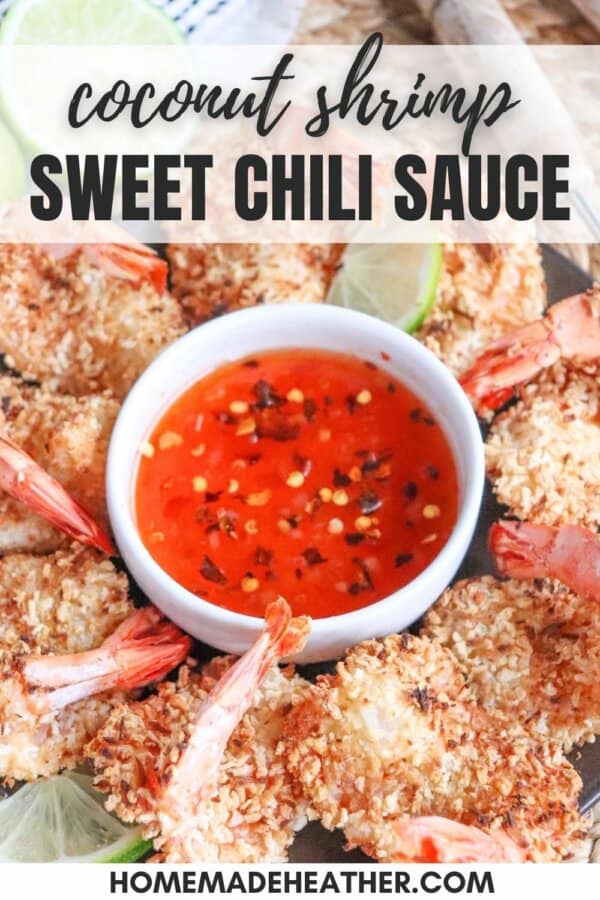 Sweet chili red sauce with red pepper chili flakes in a small white bowl surrounded by coconut shrimp.
