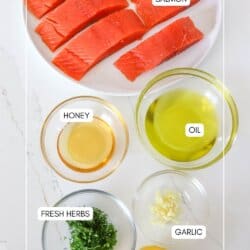 Clear glass bowls on a white counter with ingredients for a lemon salmon marinade.