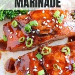 Salmon fillets covered in a rich brown sugar and bourbon glaze topped with green onions and sesame seeds on a white plate.