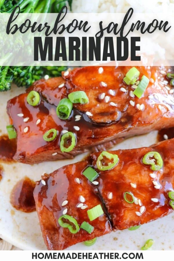 Salmon fillets covered in a rich brown sugar and bourbon glaze topped with green onions and sesame seeds on a white plate.
