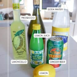 Ingredients for limoncello spritz on a white counter.