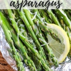Asparagus spears topped with lemon slices and shredded mozzarella in a foil packet.