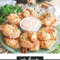 Air fried panko shrimp on a green plate surrounding spicy mayo with an air fryer in the background.
