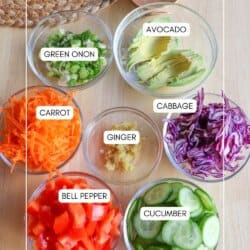 Ingredients for salmon poke bowls in clear glass bowls on a wooden table.
