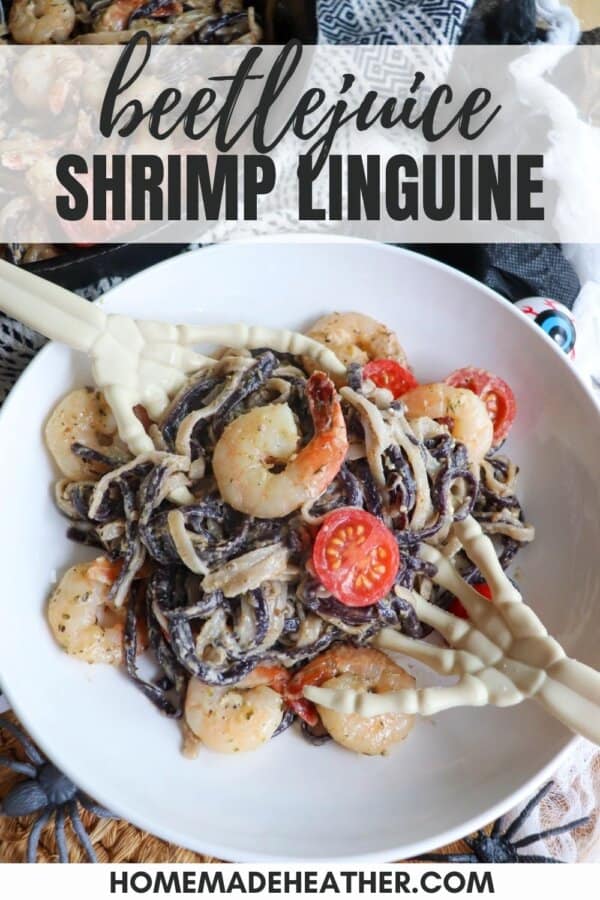 Purple and white linguine noodles in a cream sauce topped with shrimp and cherry tomatoes with skeleton hands in a white bowl.