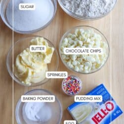 Ingredients for rainbow sprinkle pudding cookies in clear glass bowls on a wooden table.
