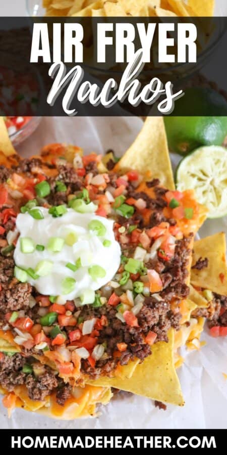 Nachos piled high with ground beef, pico and melted cheese on parchment paper.