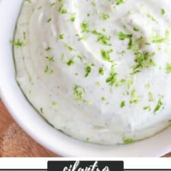 White bowl of crema sauce topped with lime zest.
