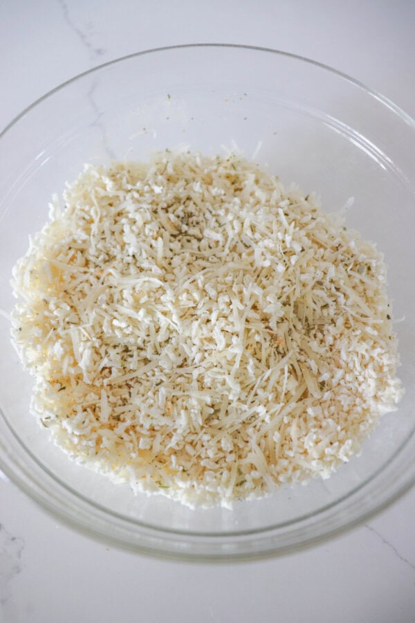 Panko bread crumbs mixed with herbs in a clear glass bowl.