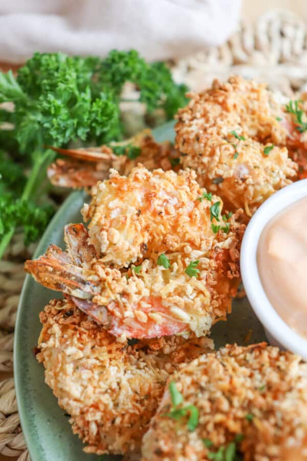 Close up of air fried panko shrimp on a green plate.