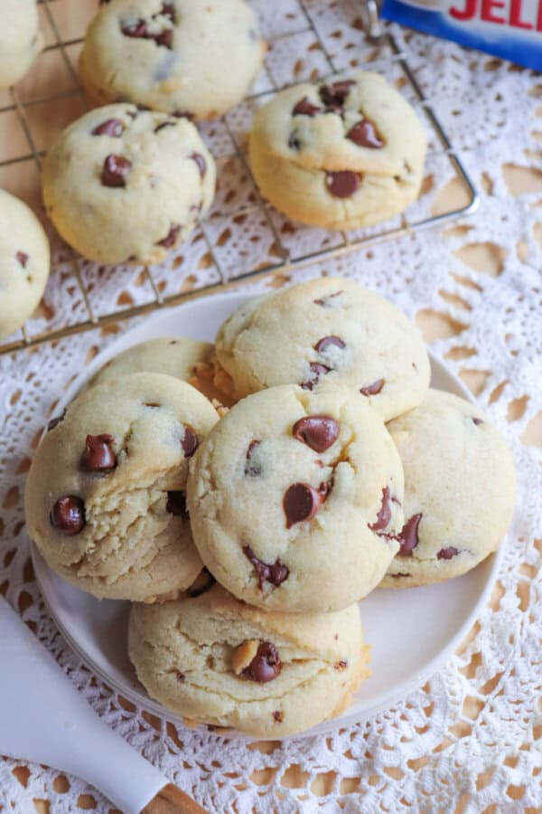 Chocolate chip cookies piled on a white plate.